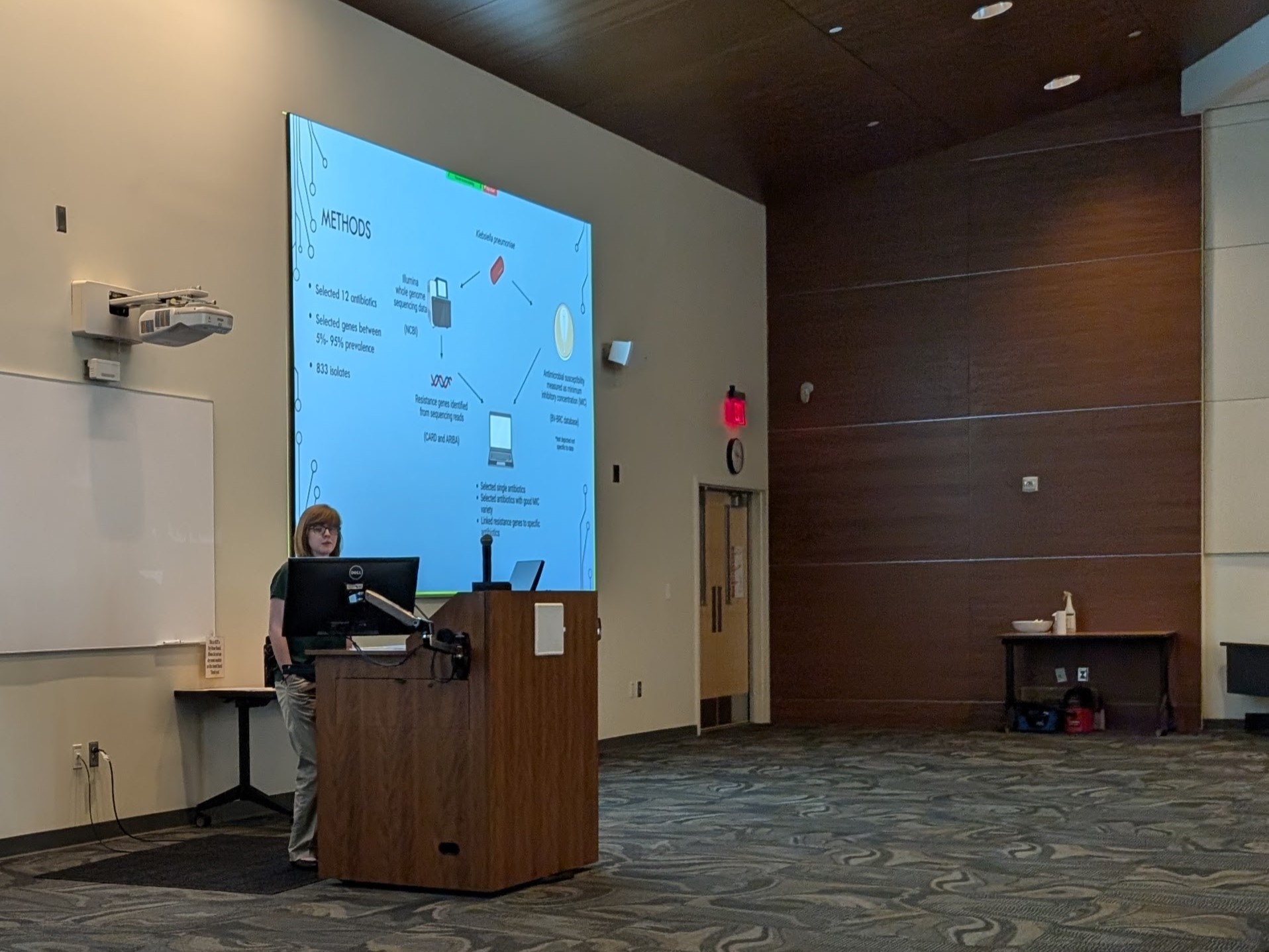 Lindsey stands at podium presenting her research